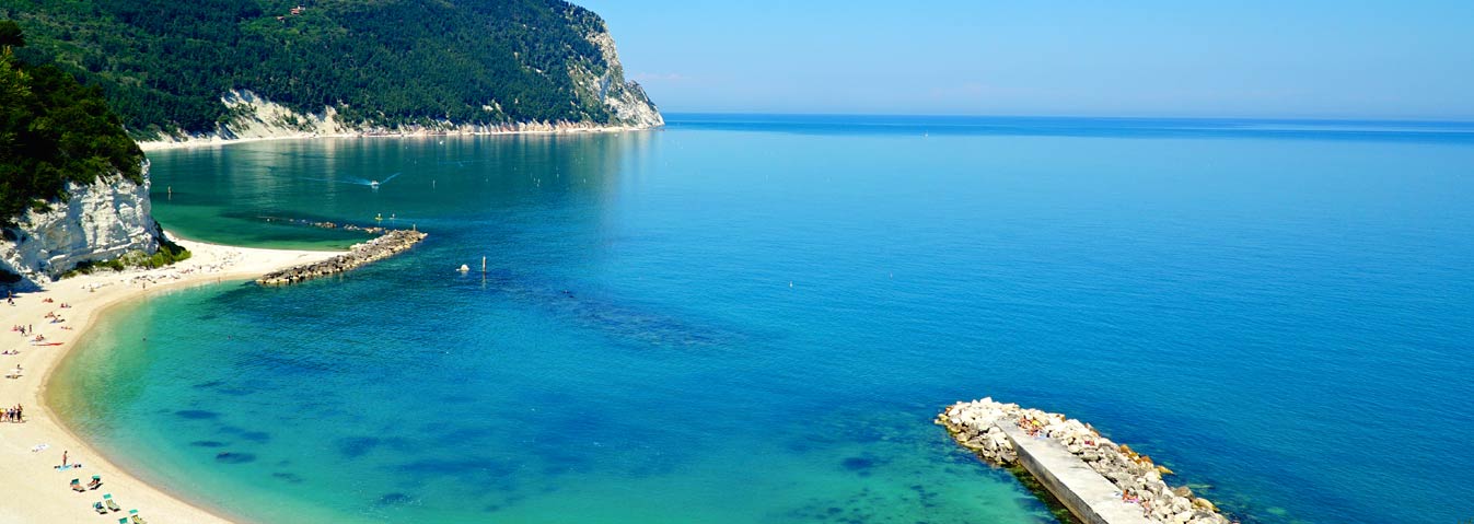 Eine blaue Bucht an der felsigen Küste von Le Marche